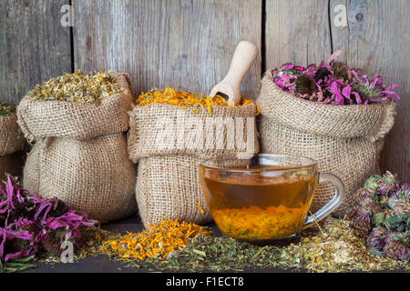 Herbes de guérison dans des sacs de jute et sain tasse de thé, de médecine de fines herbes. Banque D'Images