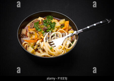 Soupe aux nouilles Lagman ouzbeks sur noir, vue du dessus Banque D'Images