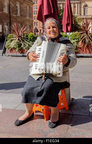 Femme jouant de l'accordéon, roumaine et arts de la rue dans le Buchanan Street, Glasgow, Scotland, UK Banque D'Images