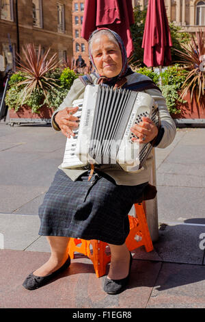 Femme jouant de l'accordéon, roumaine et arts de la rue dans le Buchanan Street, Glasgow, Scotland, UK Banque D'Images