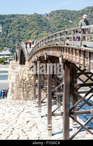 Iwakuni, Japon. Le multi-arquée pont en bois Kintaikyo, célèbre site touristique, enjambant la rivière Nishiki-gawa, avec château Iwakuni en montagne. Banque D'Images