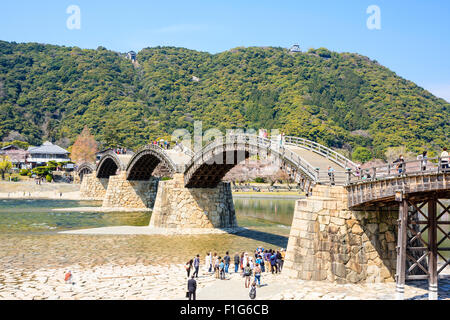 Iwakuni, Japon. Le multi-arquée pont en bois Kintaikyo, célèbre site touristique, enjambant la rivière Nishiki-gawa, avec château Iwakuni en montagne. Banque D'Images