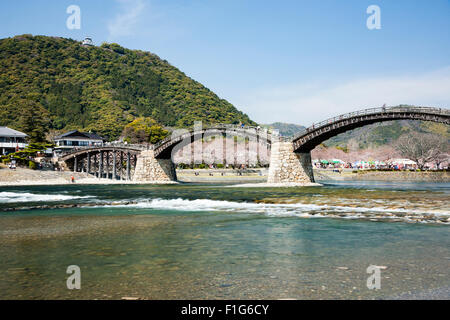 Iwakuni, Japon. Le multi-arquée pont en bois Kintaikyo, célèbre site touristique, enjambant la rivière Nishiki-gawa, avec château Iwakuni en montagne. Banque D'Images