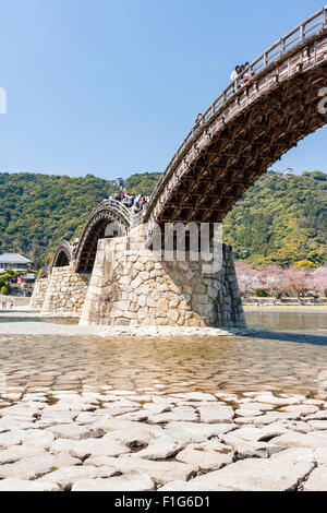 Iwakuni, Japon. Le multi-arquée pont en bois Kintaikyo, célèbre site touristique, enjambant la rivière Nishiki-gawa, avec château Iwakuni en montagne. Banque D'Images