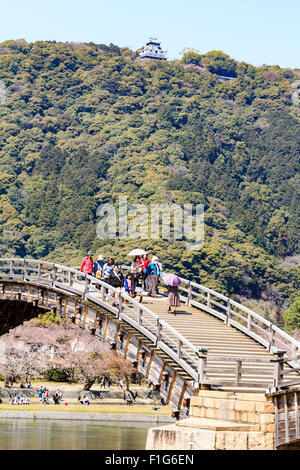 Iwakuni, Japon. Le multi-arquée pont en bois Kintaikyo, célèbre site touristique, enjambant la rivière Nishiki-gawa, avec château Iwakuni en montagne. Banque D'Images