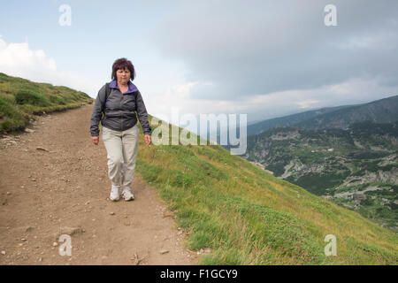 Hauts femme marche dans la montagne. Banque D'Images