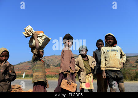 Les jeunes enfants malagasy transportant briques sur leur tête. Banque D'Images