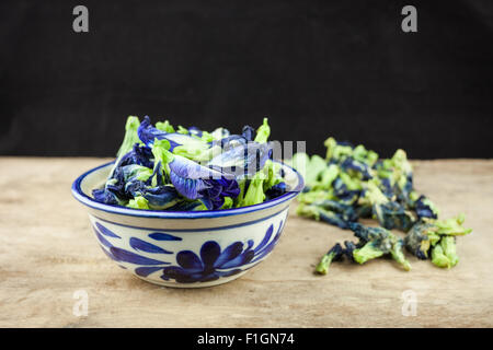 Papillon fleur de pois frais, Clitoria ternatea sur planche de bois. Banque D'Images