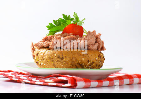 Petit pain frais en pâte, tomate cerise et le persil sur plaque blanche et torchon à carreaux Banque D'Images