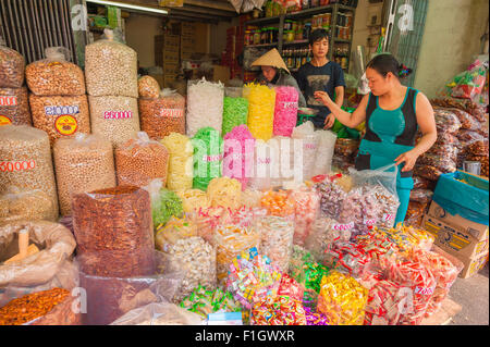 Marché du Vietnam, un écran couleur de bonbons et des écrous sur la vente à l'extérieur d'une boutique dans le marché Binh Tay dans Cholon, le domaine de Saigon, Ho Chi Minh City, Vietnam. Banque D'Images