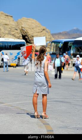 Excursion guidée rep holding up tour numéros voyage pour les passagers, lorsqu'ils arrivent dans le port de Santorin d''Ormos Athinios Banque D'Images