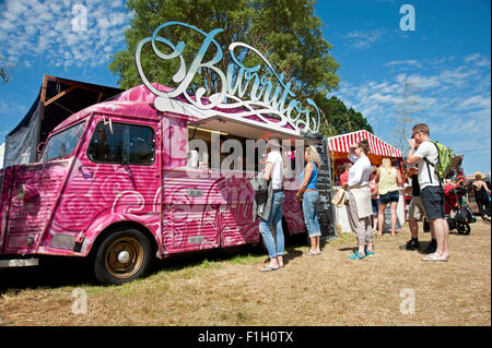 Festivaliers file d'attente pour les burritos à une cuisine mobile dans le soleil de l'été au Port Eliot Cornwall Festival Banque D'Images