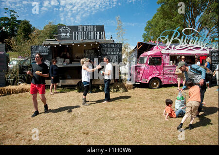 Festivaliers file d'attente pour les burritos à une cuisine mobile dans le soleil de l'été au Port Eliot Cornwall Festival Banque D'Images