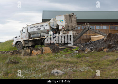 Un homme lave l'équipement après une mise en place de béton pour une nouvelle extension pour le centre de visiteurs à Gullfoss, Islande Banque D'Images