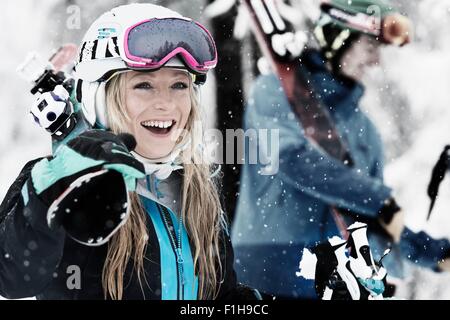 Mid adult woman holding skis, rire Banque D'Images