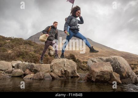 Couple crossing river, Conte de piscines, près de Glenbrittle, île de Skye, Hébrides, Ecosse Banque D'Images