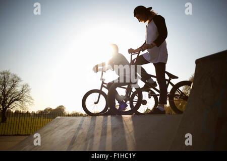 Deux jeunes hommes sur vélos bmx au skatepark Banque D'Images