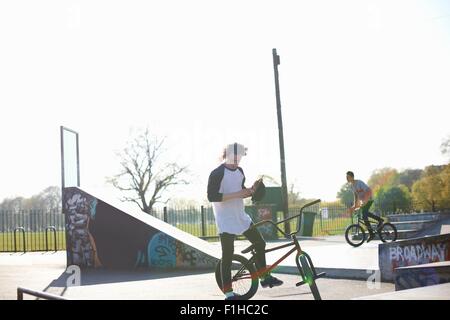 Deux jeunes hommes sur vélos bmx au skatepark Banque D'Images