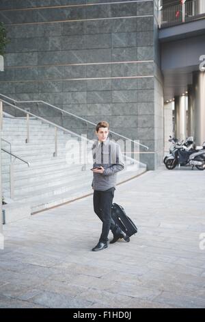 Les jeunes de banlieue businessman walking with suitcase. Banque D'Images