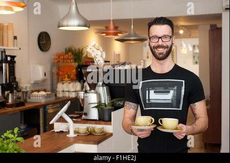 Portrait de cafe waiter serving tasses de café Banque D'Images