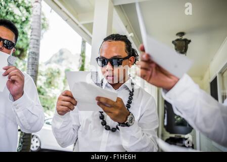 Les jeunes hommes se préparer à porter de mariage hawaïen perles kukui nut, Kaaawa, Oahu, Hawaii, USA Banque D'Images