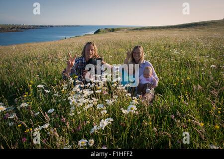 Portrait of family sitting on hillside, White strand, comté de Clare, Irlande Banque D'Images