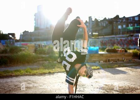 Les jeunes femmes faisant l'envers breakdancing gel, looking at camera Banque D'Images