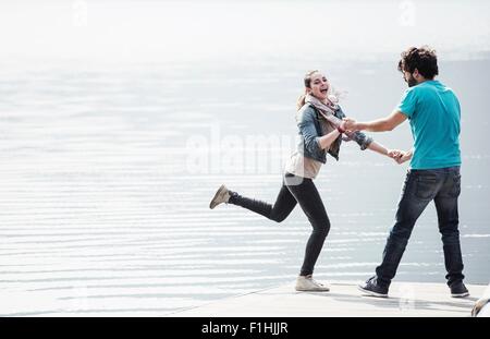 Jeune couple couchait sur la jetée au lac Mergozzo, Verbania, Piemonte, Italie Banque D'Images