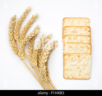 Craquelins au fromage ou des biscuits et des épis de blé isolé sur un fond blanc. Banque D'Images