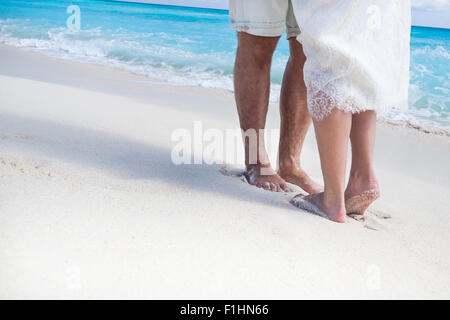 Gros plan sur les pieds mâles et femelles, les baisers de sable blanc Banque D'Images