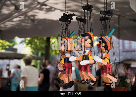 Jouets en bois Pinocchio et autres objets d'intérêt à vendre sur un marché du samedi le long du Dijver à côté du canal, Bruges. Banque D'Images