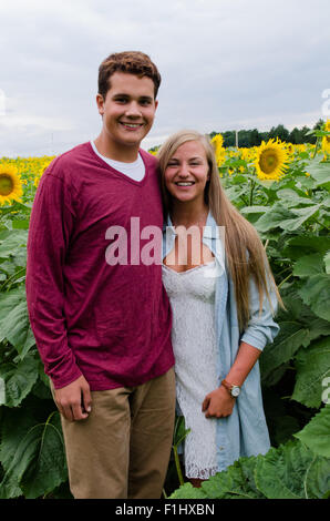 Jeune couple pose pour photo dans champ de tournesol. Banque D'Images