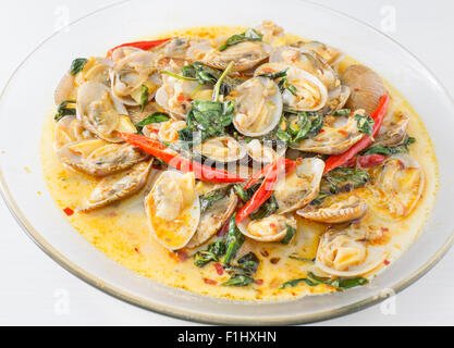 Palourdes sautées avec pâte de piment grillées et de feuilles de basilic thaï. Banque D'Images