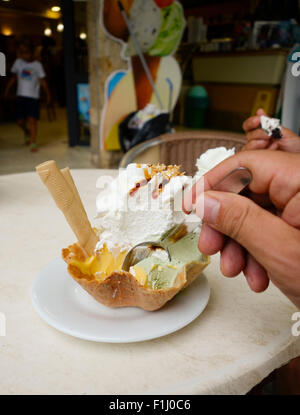 Cuillère avec la main vers de waffle rempli de crème glacée, gelato italien, Espagne Banque D'Images