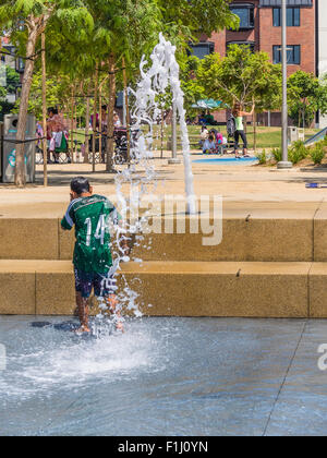 Garçon jouant dans l'eau Fontaine à Waterfront Park, San Diego, Californie. Banque D'Images