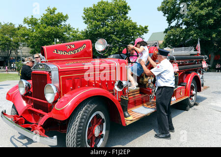 Ancien pompier, montrer aux enfants un ancien camion de pompiers de New York Long Island Greenport Banque D'Images