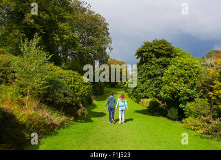 Jeune couple en train de marcher le long de la terrasse dans les jardins du château de Muncaster, West Yorkshire, England UK Banque D'Images