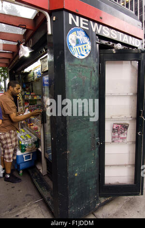 L'homme l'achat d'articles dans un trottoir Kiosque sur une rue de Manhattan à New York City Banque D'Images