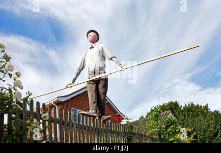 Un épouvantail avec balancier sur le haut d'une clôture de jardin en bois. Banque D'Images