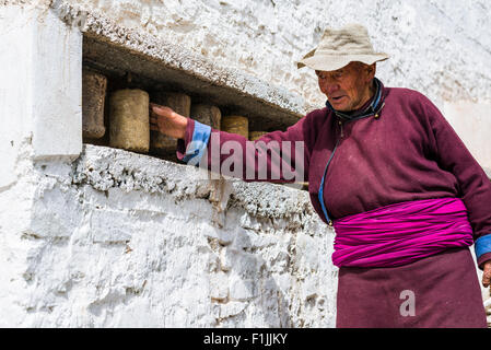 Un vieil homme ladakhis tourne une roue de prière à un mur de Hemis Gompa, Hemis, le Jammu-et-Cachemire, l'Inde Banque D'Images