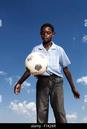 Élève de l'école africaine joue avec un ballon de foot Banque D'Images