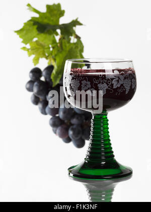 Verre de vin rouge et les raisins rouges frais Banque D'Images