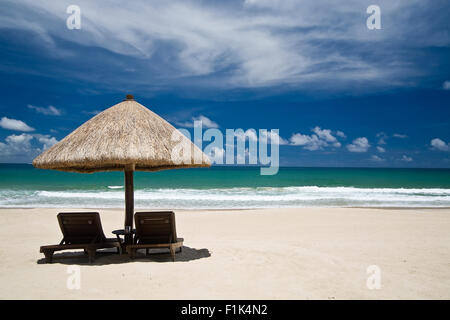 Plage avec un parasol et chaises Banque D'Images