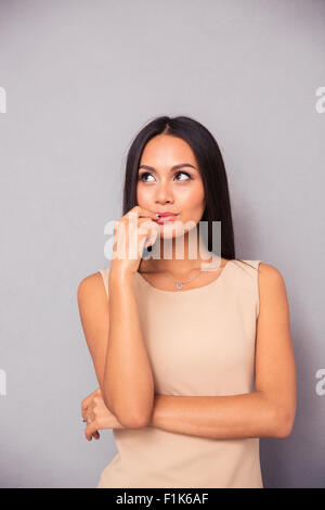 Portrait d'une femme en tenue debout sur fond gris et jusqu'à la Banque D'Images