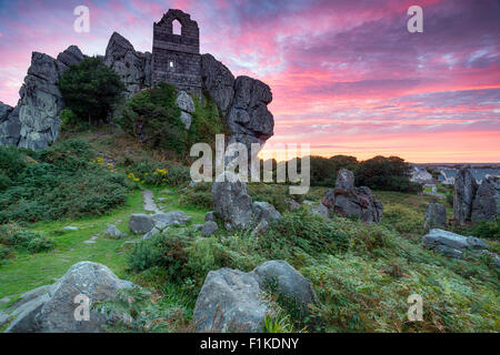 Ciel coucher de soleil spectaculaire sur roche roche, les ruines d'une ancienne chapelle perchée sur un éperon rocheux de granit à la Roche près de St Auste Banque D'Images