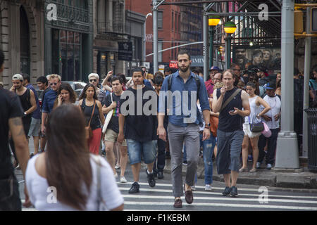 Les gens traversent Broadway dans le quartier Soho de la hanche le long de Broadway à New York City. Banque D'Images