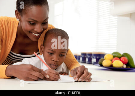 Jeune mère africaine aider son fils avec ses devoirs Banque D'Images