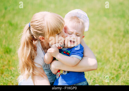 Heureux Petit Garçon enfant et sa mère jouant dans l'herbe verte d'été pré, Parc, Journée ensoleillée Piscine Banque D'Images