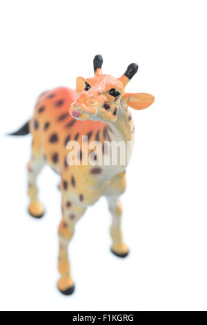 Un petit jouet girafe isolé sur un fond blanc. Banque D'Images
