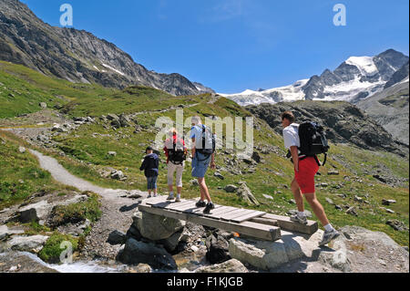 Les marcheurs / les randonneurs à marcher le long du chemin de montagne vers le glacier de Moiry dans les Alpes Pennines, Valais / Wallis (Suisse) Banque D'Images